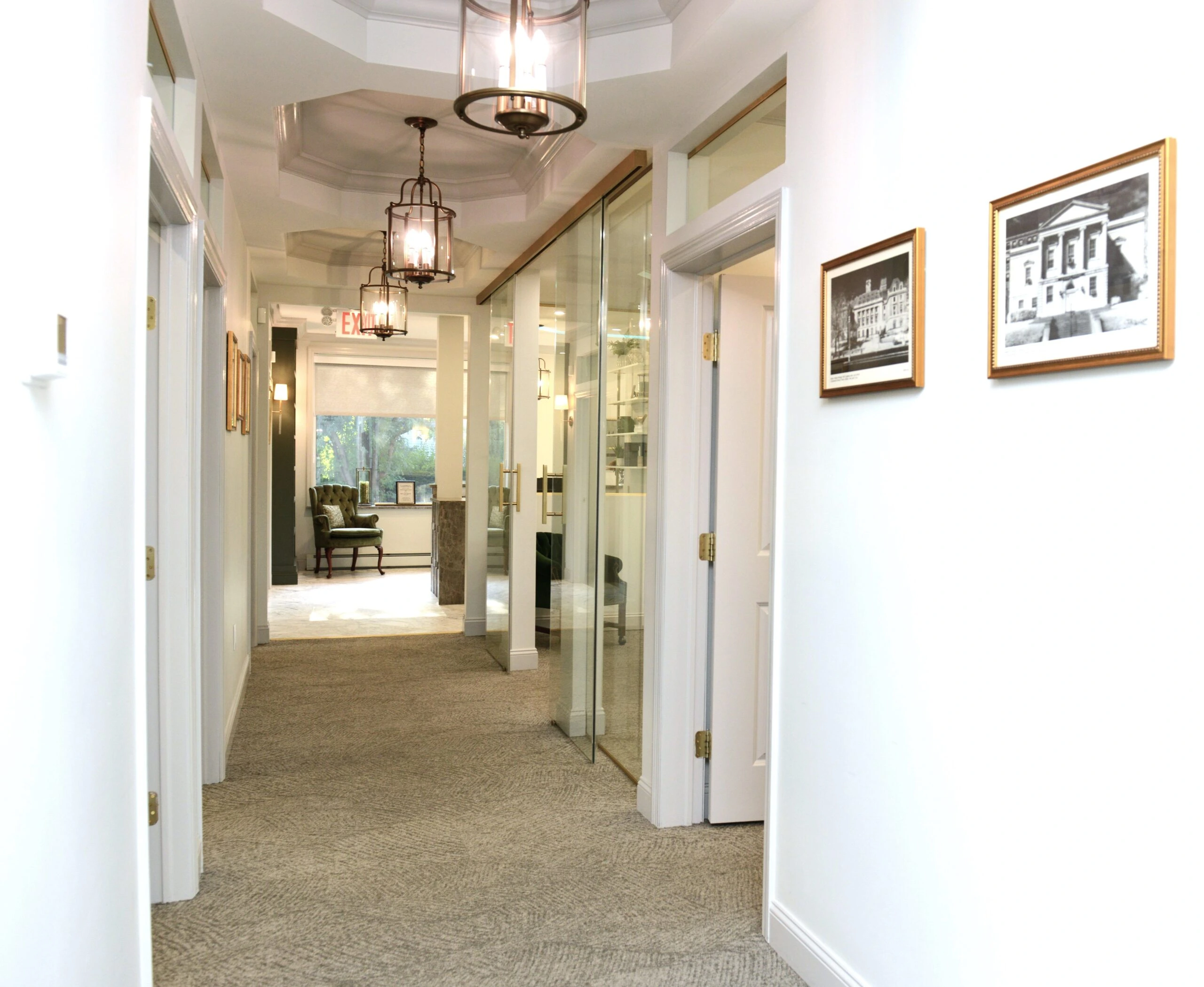 Law firm corridor with modern office hallway, glass doors, professional workspace design, neutral decor, office lighting, framed artwork, and functional office interiors.