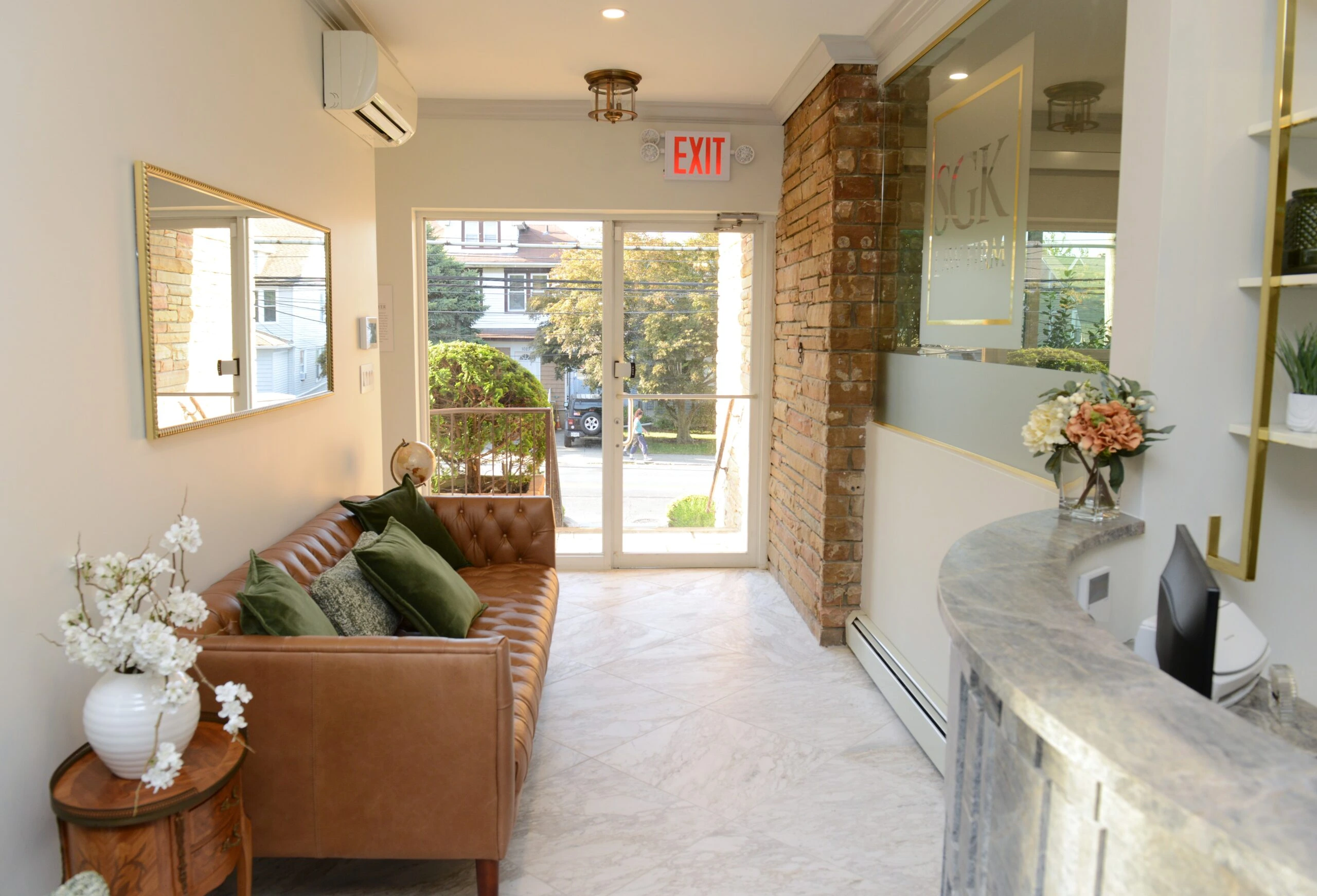 Law firm waiting area with elegant office design, professional reception space, modern office decor, leather sofa, exposed brick wall, marble flooring, and stylish office interiors.