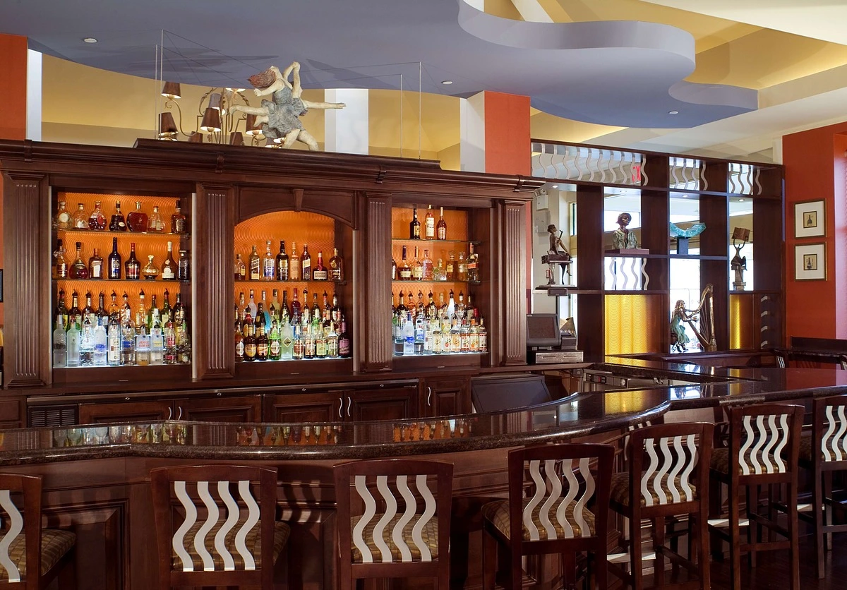 Sophisticated tea house bar with illuminated pendant lights, a red mosaic bar counter, and a view of a traditional Chinese garden with a pagoda.
