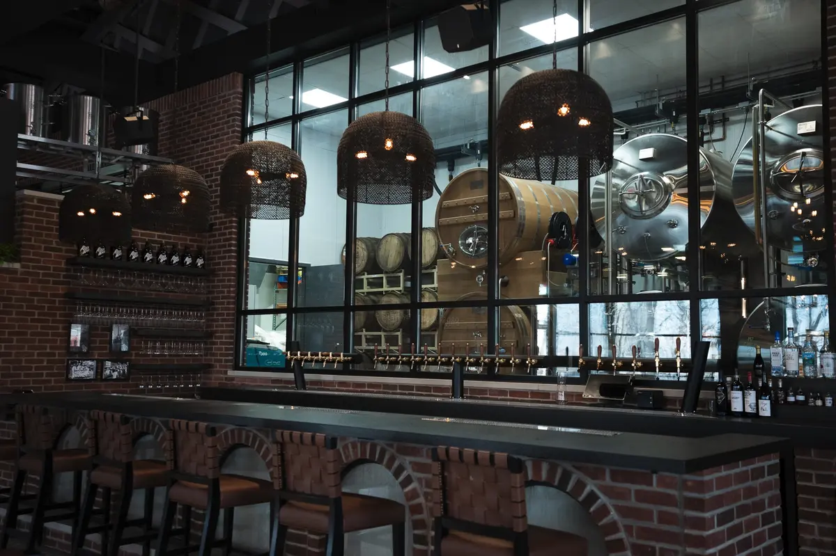 Craft beer bar with brick wall aesthetics, industrial design, and a welcoming community gathering atmosphere.