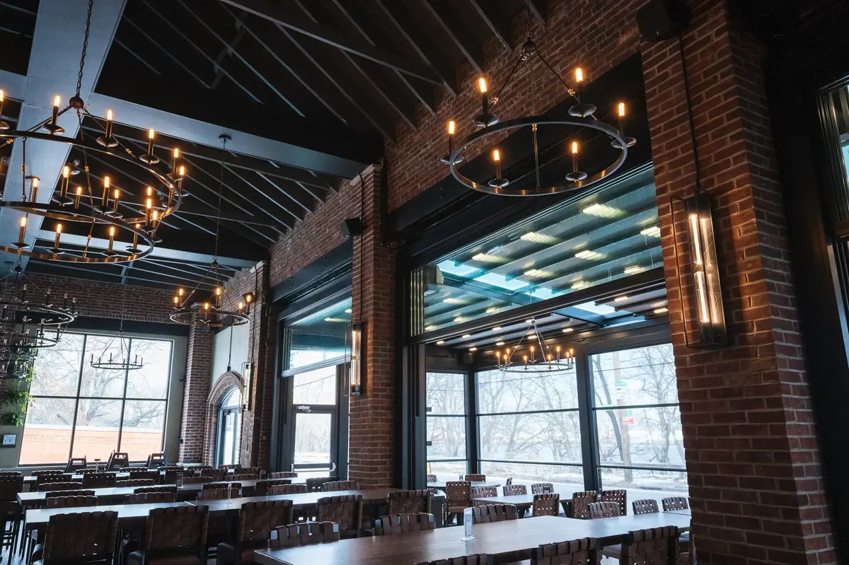 Rustic industrial brewery interior with exposed brick, modern decor, and a craft beer restaurant atmosphere.