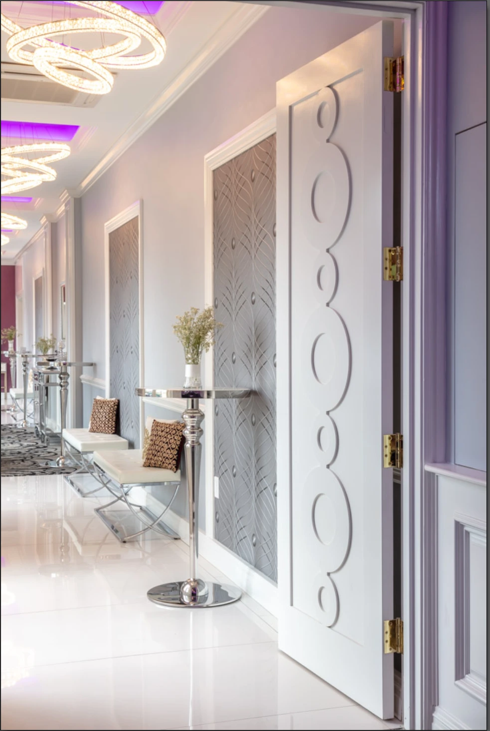 Entrance doors leading to a luxury party room with custom circular-patterned wallpaper, decorative walls, and upscale event design.