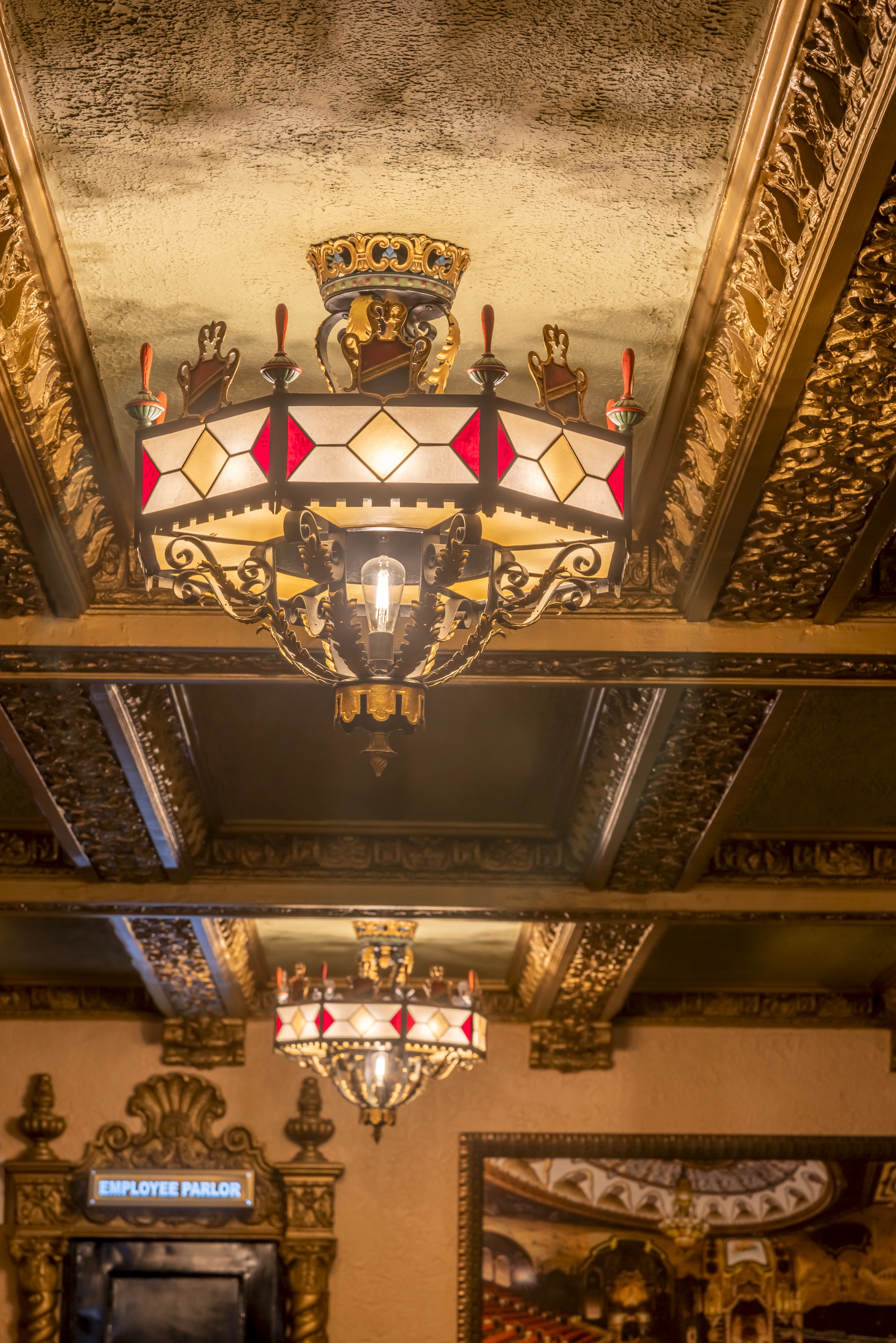 VG Lounge at Saint George Theatre with a restored 1929 chandelier, vintage lighting, ornate moldings, and classic design elements in a historic landmark.