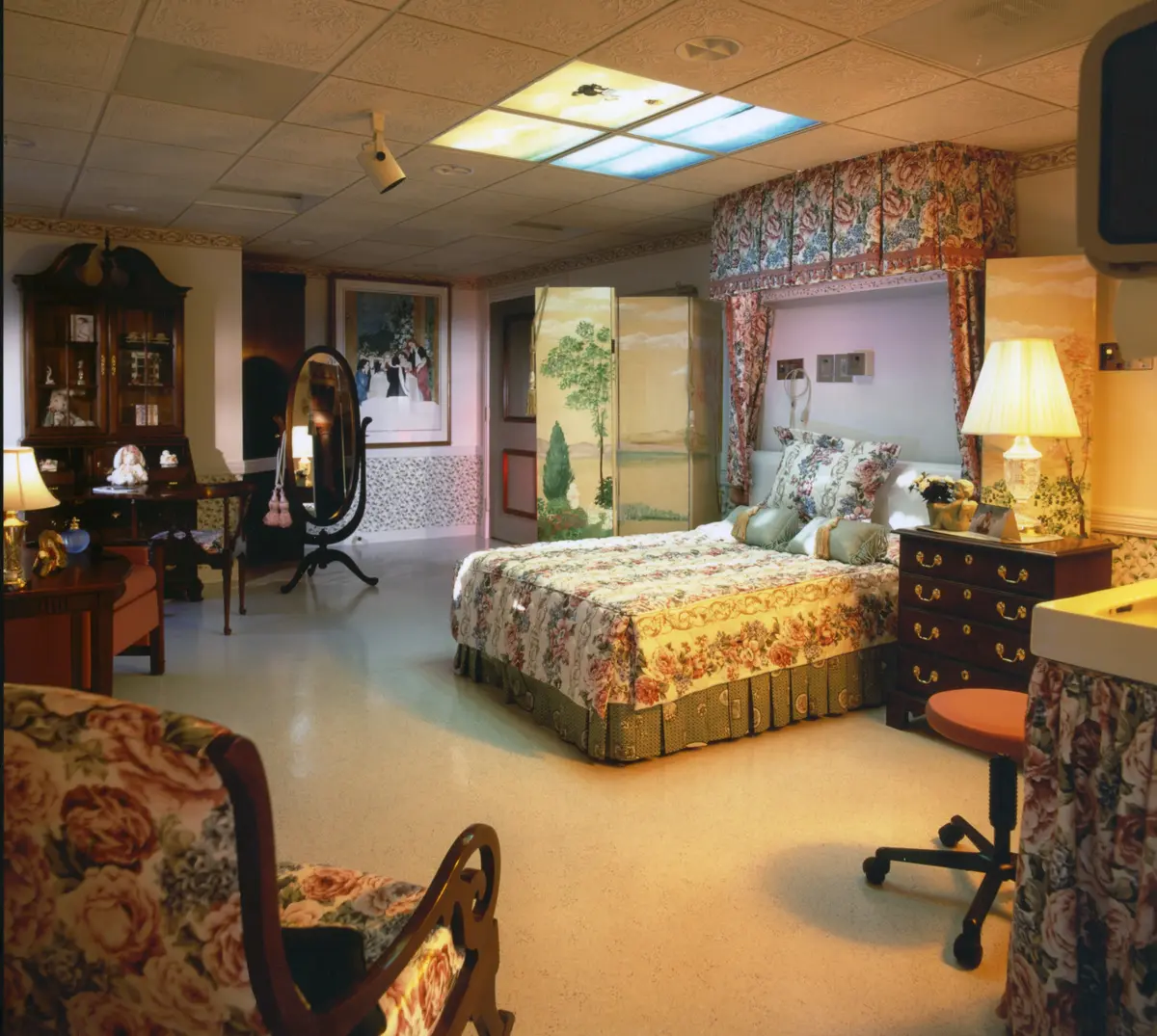 Luxury birthing suite with a cozy maternity room, serene decor, and a backlit ceiling for a calming atmosphere.