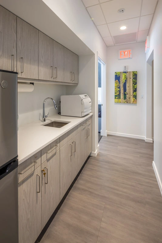 Organized medical prep area with ample cabinetry, durable countertops, and a sterile, efficient workspace