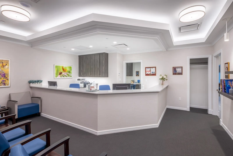 Modern medical office reception with healing floral art, floating shelves, and a sophisticated yet calming ambiance.