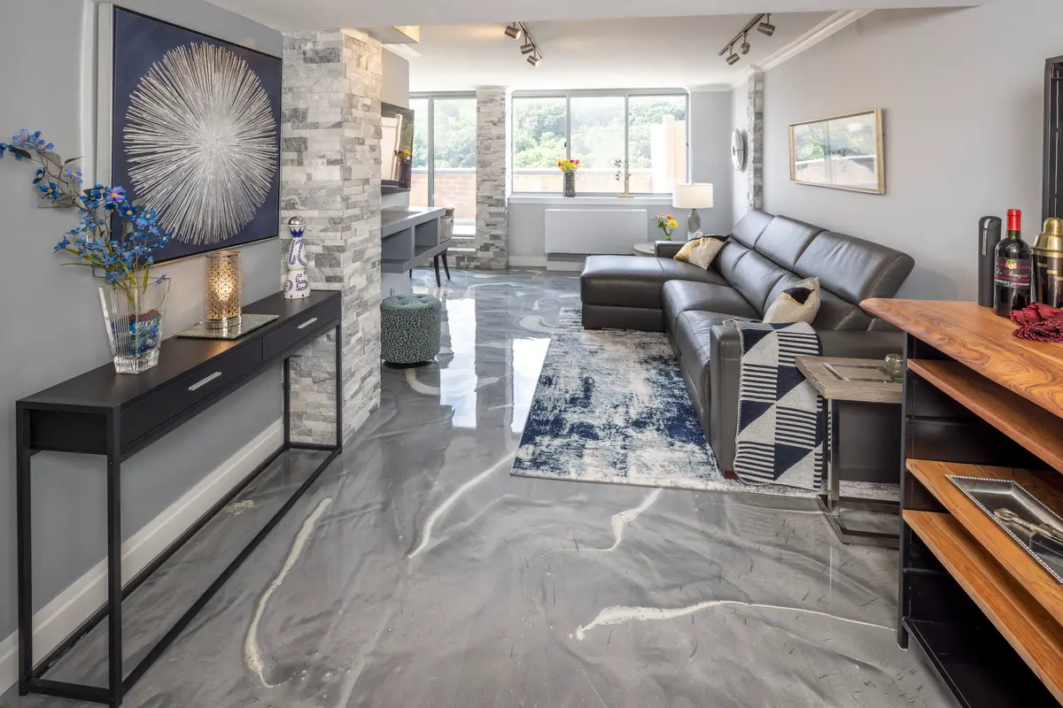 A sleek modern condo hallway with polished floors, ambient lighting, and stylish artwork, leading to a contemporary living space.