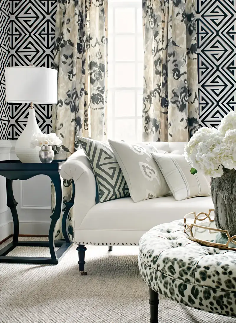 A neutral fabric sofa pairs seamlessly with patterned drapery, while custom pillows introduce a pop of interest with bold geometric designs.